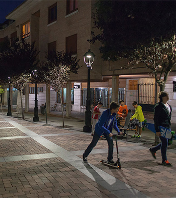 Ihmisiä kävelemässä öisellä palencialaisella kadulla, jossa on Philipsin katuvalaistus