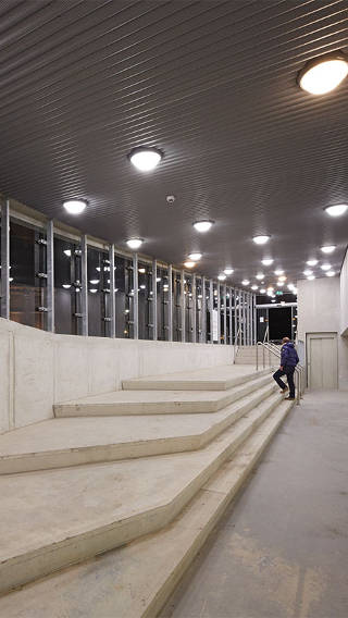  Mies kiipeää portaita Philipsin valoilla valaistussa Eiterenin pysäköintihallissa 