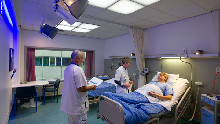 Lääkärit hoitavat potilaita Philips Healwell -valaistusjärjestelmällä valaistussa huoneessa