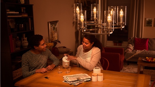 Kaksi ihmistä istuu kotona sohvalla nauttien korkealaatuisesta LED-valosta