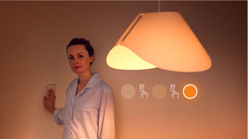 Nainen muuttaa huoneen kirkkautta SceneSwitch-lampun avulla
